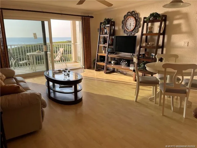 a living room with furniture and a floor to ceiling window