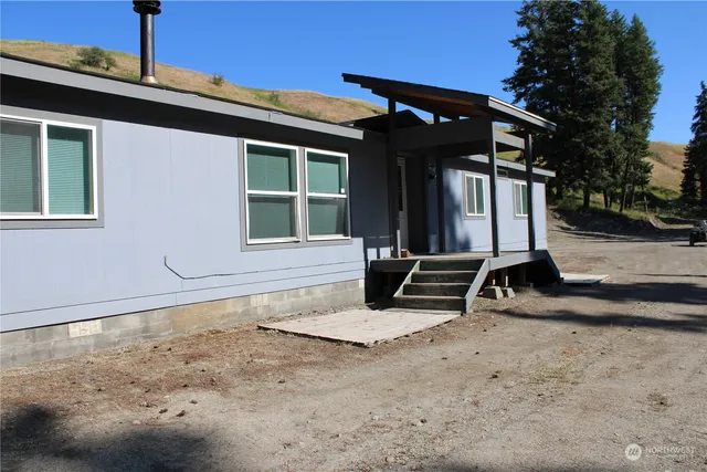 a view of a house with backyard and sitting area