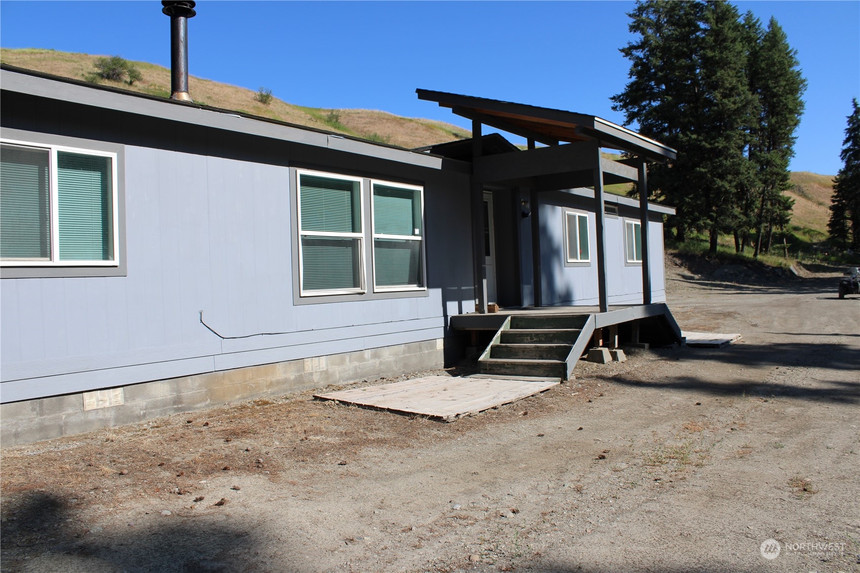 110 Bartroff Road Oroville, WA 98844 - Photo 1 of 38 a view of a house with backyard and sitting area