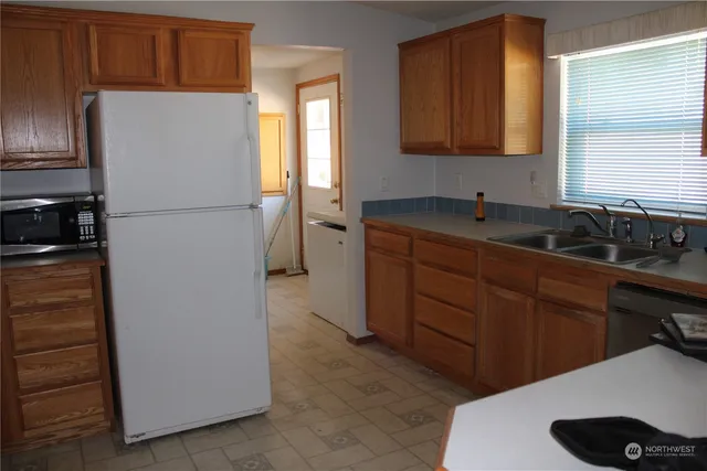 a kitchen with stainless steel appliances granite countertop a refrigerator a stove a sink and dishwasher