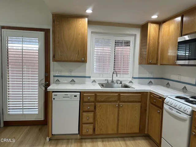 a kitchen with a sink cabinets and wooden floor