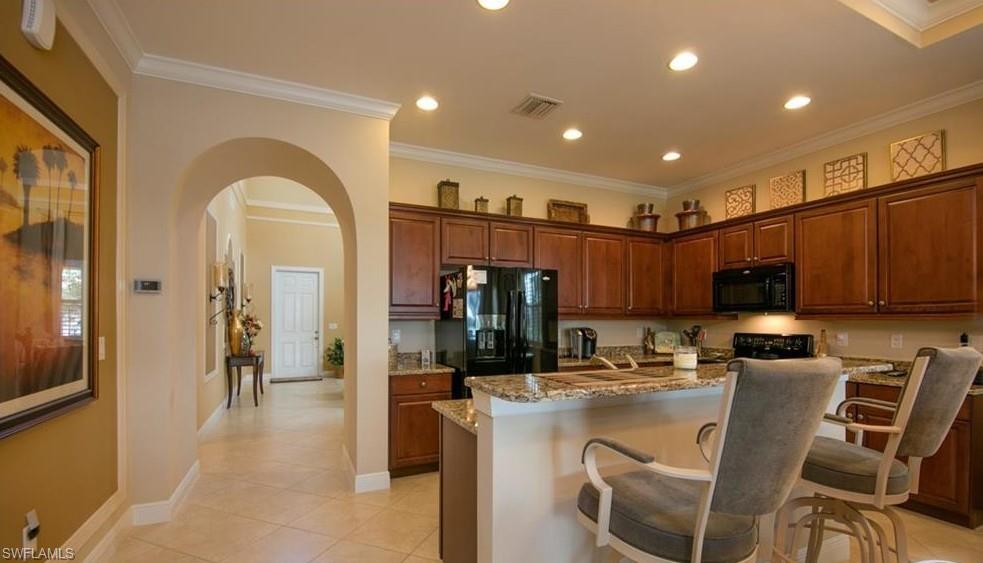 13644 Manchester Lane Naples, FL 34109 - Photo 13 of 18 a kitchen with a refrigerator and a dining table