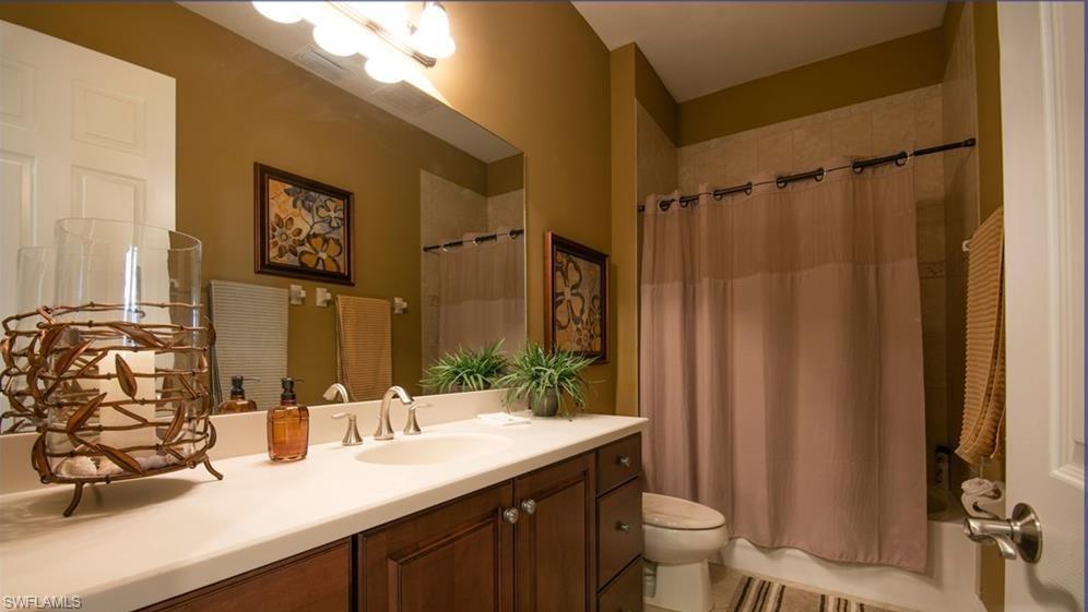 13644 Manchester Lane Naples, FL 34109 - Photo 8 of 18 a bathroom with a double vanity sink toilet and a mirror