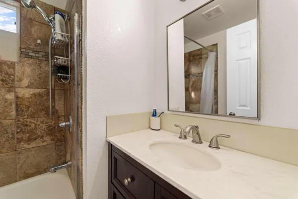 a bathroom with a granite countertop sink and a mirror