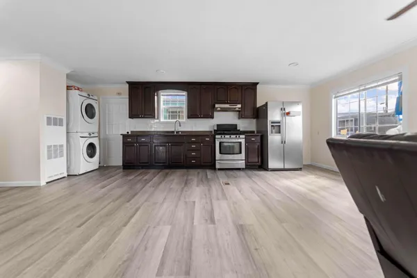 a large kitchen with wooden floors and stainless steel appliances