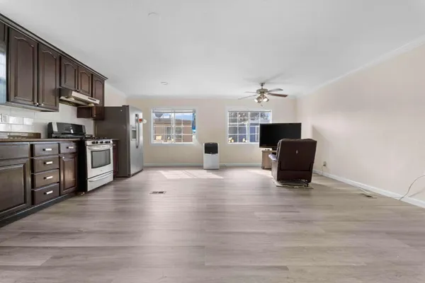 a view of a kitchen with furniture and wooden floor