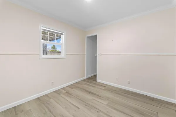 an empty room with wooden floor and window