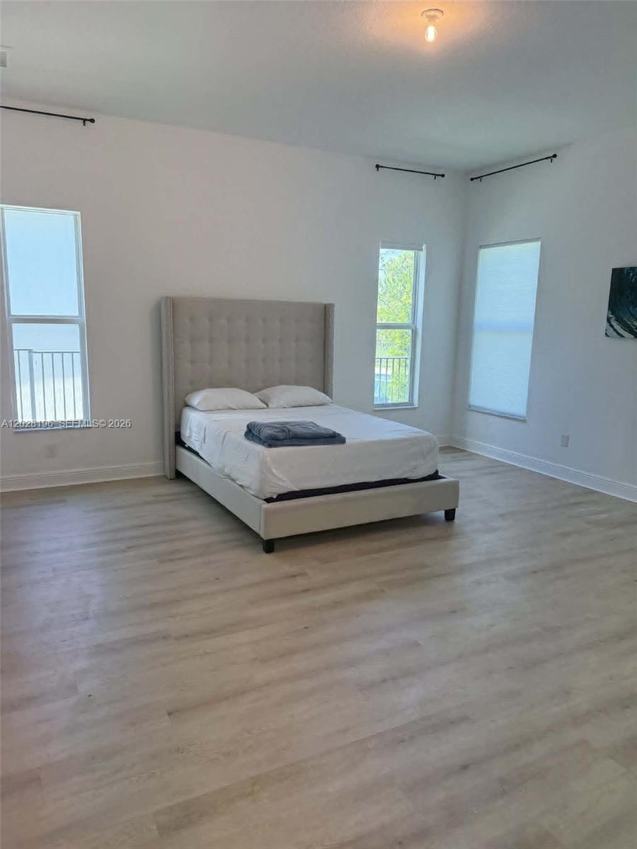 4710 Southwest Ardsley Drive Stuart, FL 34997 - Photo 5 of 7 a spacious bedroom with a bed and window