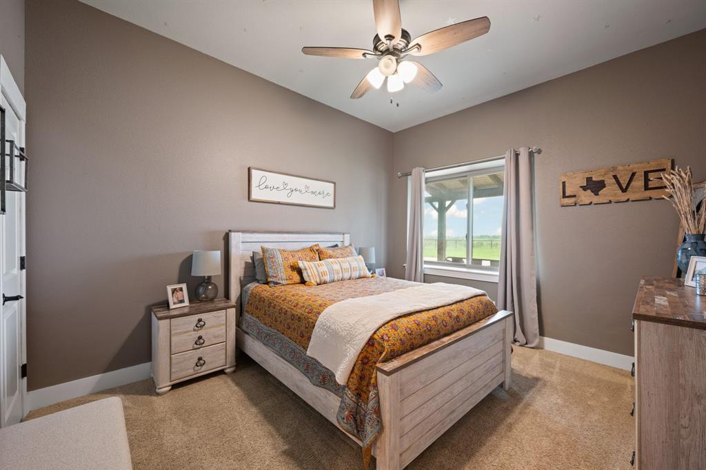 290 Barton Road Maypearl, TX 76064 - Photo 17 of 34 a bedroom with a bed and a chandelier