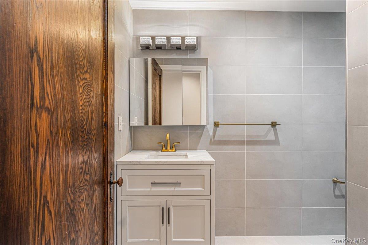 952 Cedar Swamp Road Glen Head, NY 11545 - Photo 42 of 50 a bathroom with a sink and a mirror