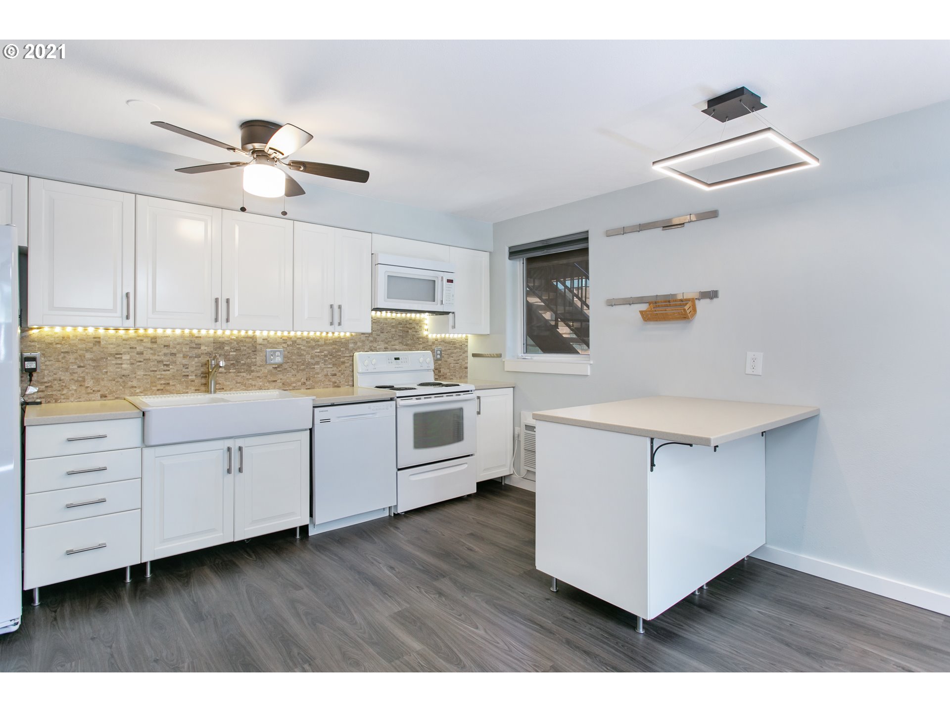 10345 Northeast Clackamas Street, Unit 2 Portland, OR 97220 - Photo 10 of 28 a kitchen with cabinets wooden floor and stainless steel appliances