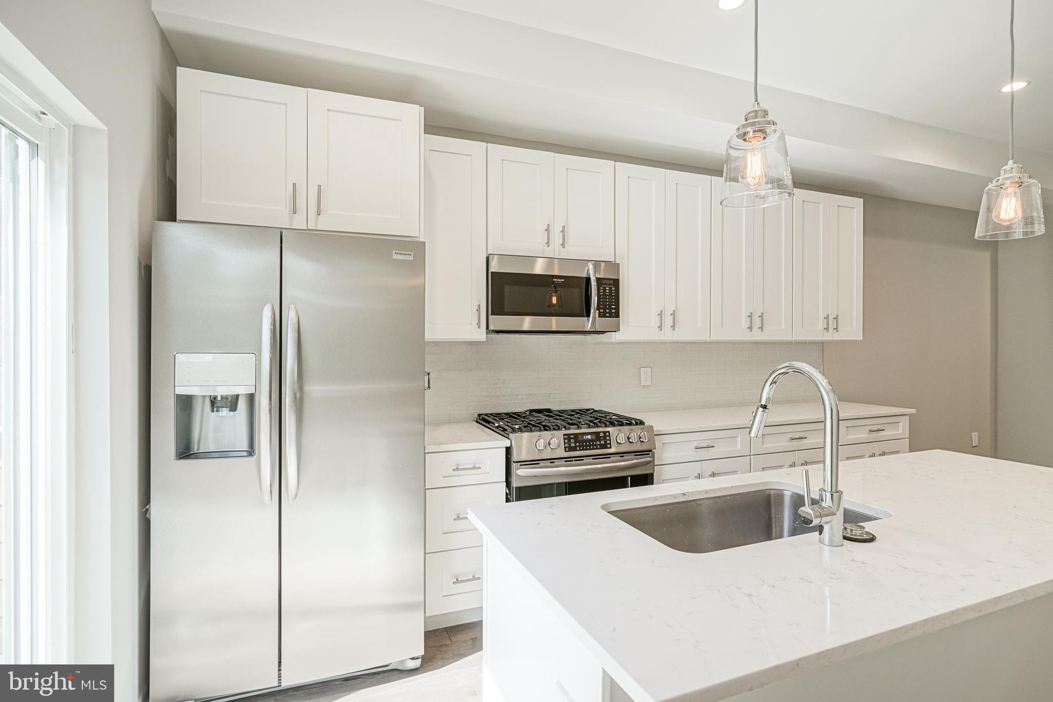 542 Pierce Street Philadelphia, PA 19148 - Photo 11 of 36 a kitchen with stainless steel appliances granite countertop a refrigerator sink and white cabinets