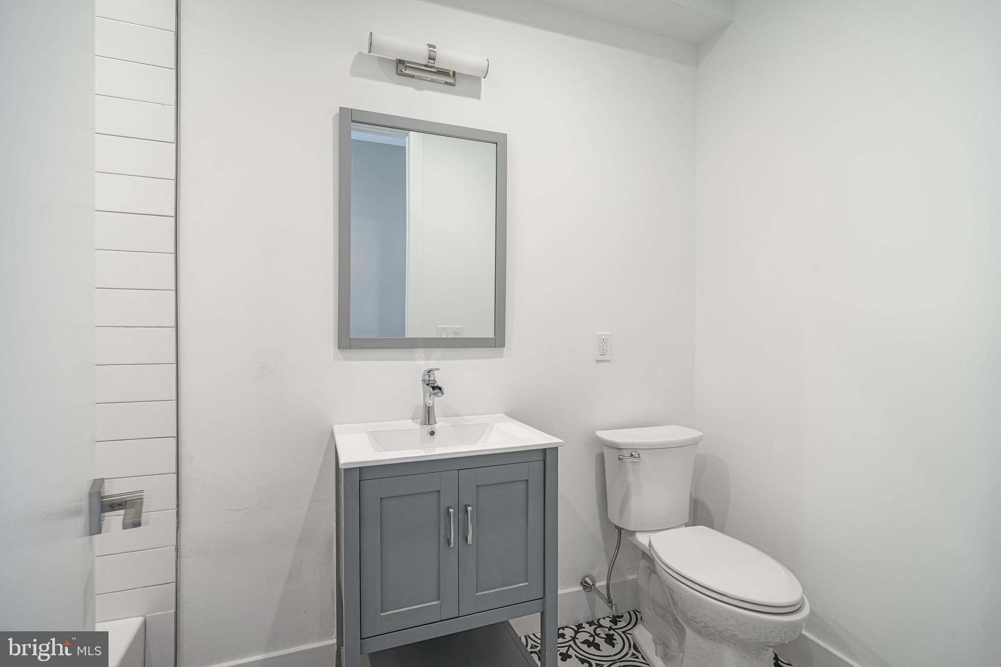 542 Pierce Street Philadelphia, PA 19148 - Photo 16 of 36 a bathroom with a toilet a sink and mirror