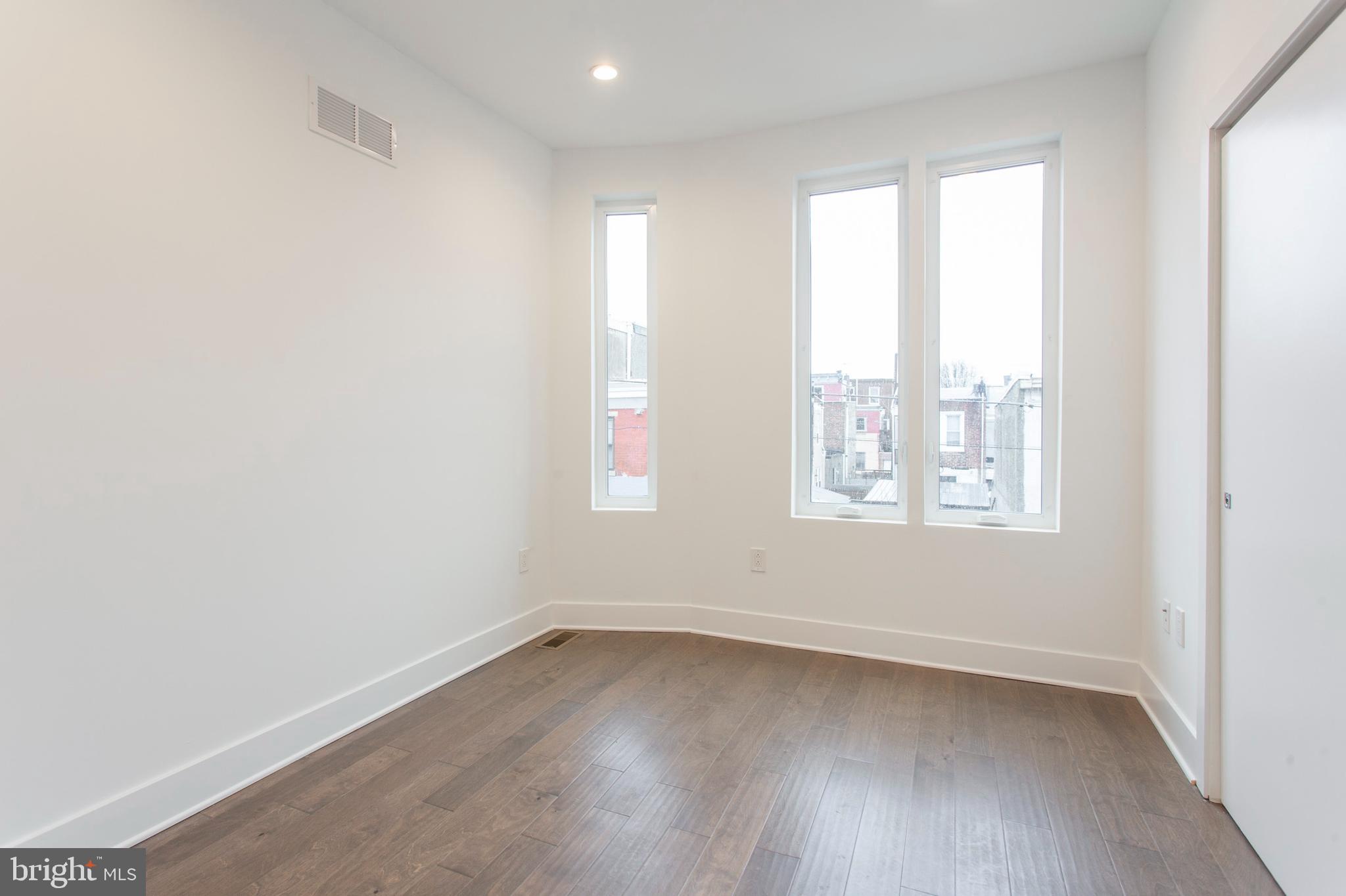 542 Pierce Street Philadelphia, PA 19148 - Photo 18 of 36 an empty room with wooden floor and windows
