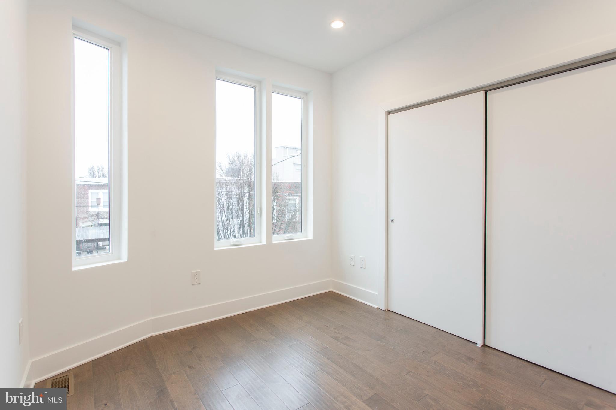 542 Pierce Street Philadelphia, PA 19148 - Photo 19 of 36 a view of an empty room with wooden floor and a window