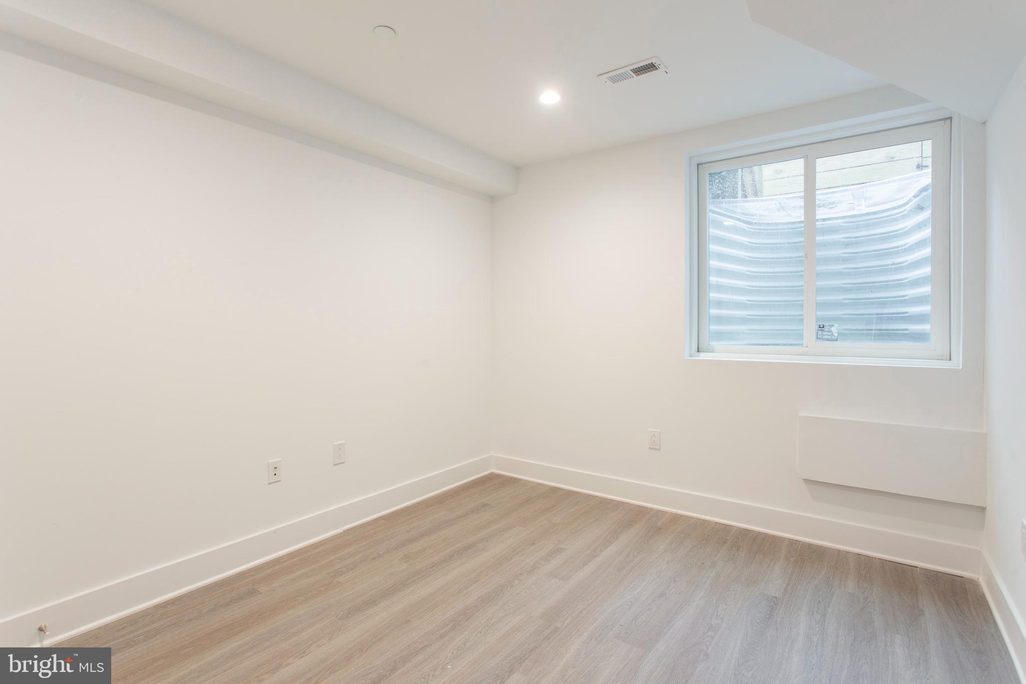 542 Pierce Street Philadelphia, PA 19148 - Photo 28 of 36 an empty room with wooden floor and windows