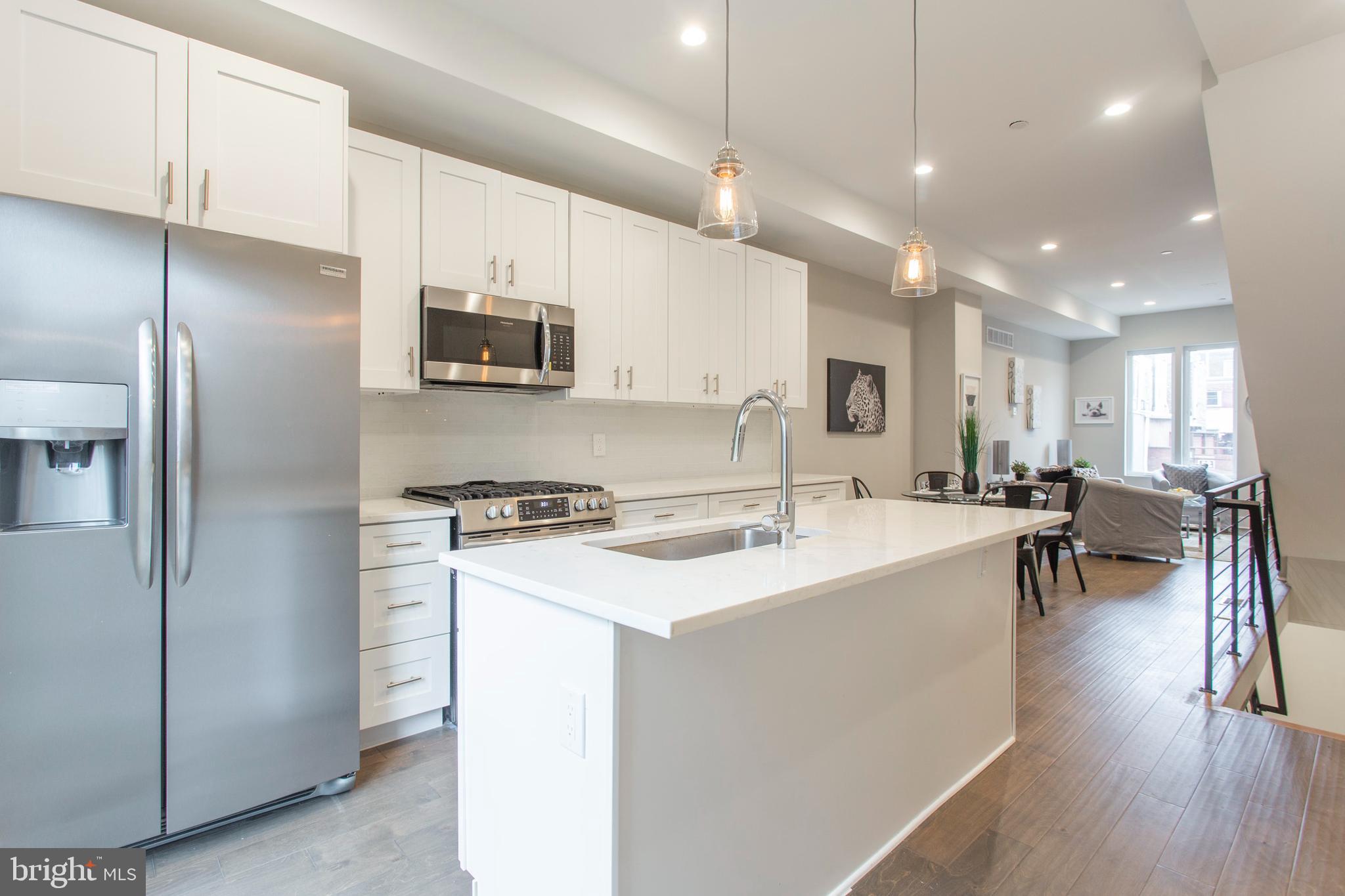 542 Pierce Street Philadelphia, PA 19148 - Photo 9 of 36 a kitchen with a sink a stove a refrigerator and chairs