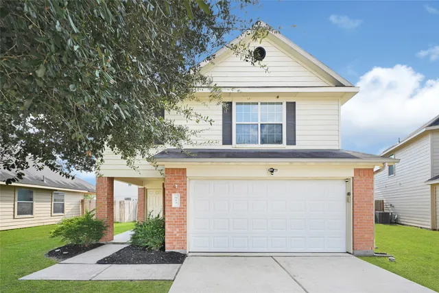 a front view of a house with a yard and garage