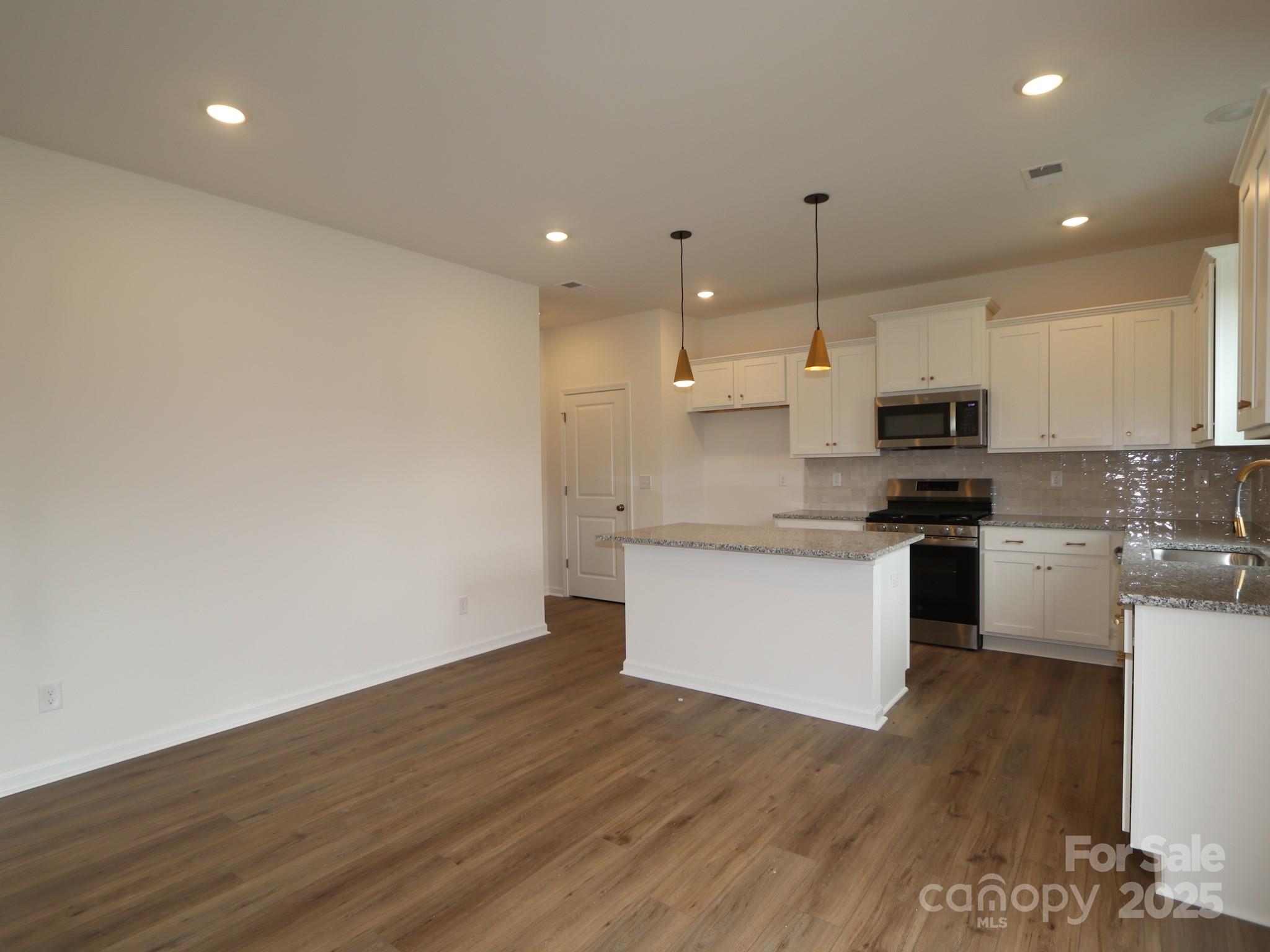 908 Barker Street Monroe, NC 28112 - Photo 6 of 16 a kitchen with granite countertop white cabinets and white appliances