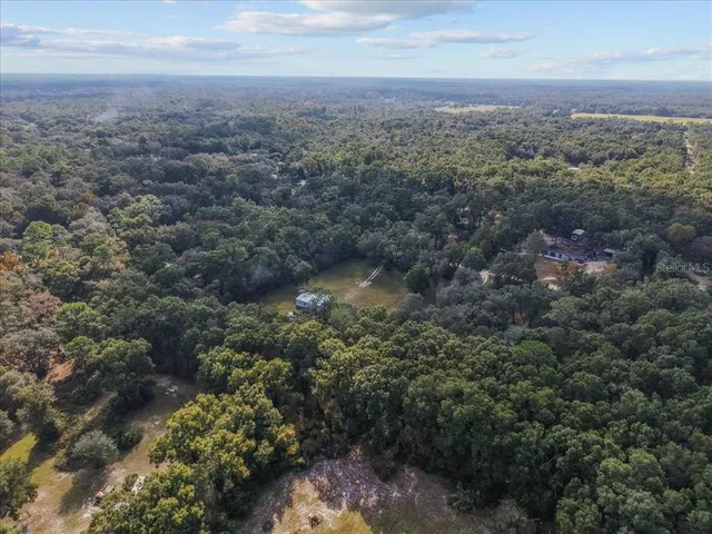an aerial view of house with yard and mountain view in back