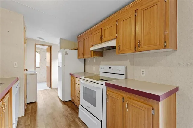 a kitchen with stainless steel appliances granite countertop a refrigerator and a stove