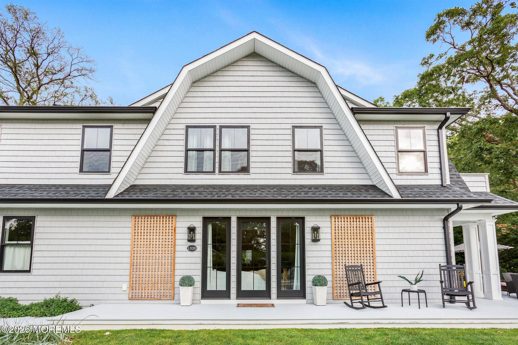 1320 Charles Street Point Pleasant, NJ 08742 - Photo 2 of 41 a view of a white house with large windows and a yard