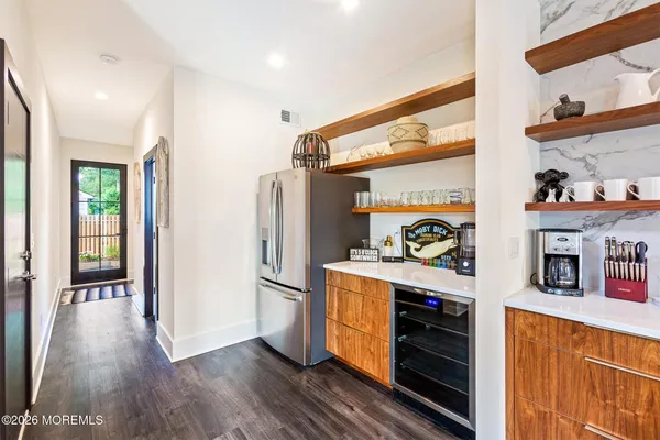 a kitchen with stainless steel appliances a refrigerator and a wooden floor