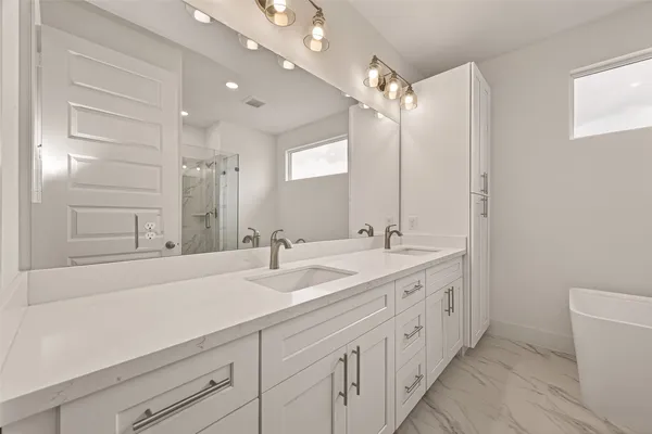 a spacious bathroom with a double vanity sink mirror and double