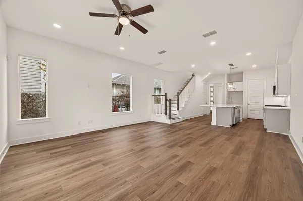 a view of a big room with wooden floor and windows