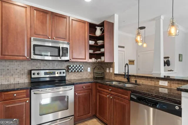a kitchen with stainless steel appliances granite countertop a refrigerator and a stove top oven