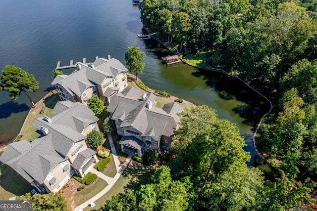 an aerial view of a house with swimming pool and lake view