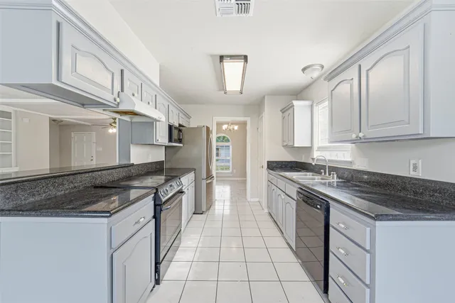 a kitchen with stainless steel appliances granite countertop a stove and a sink