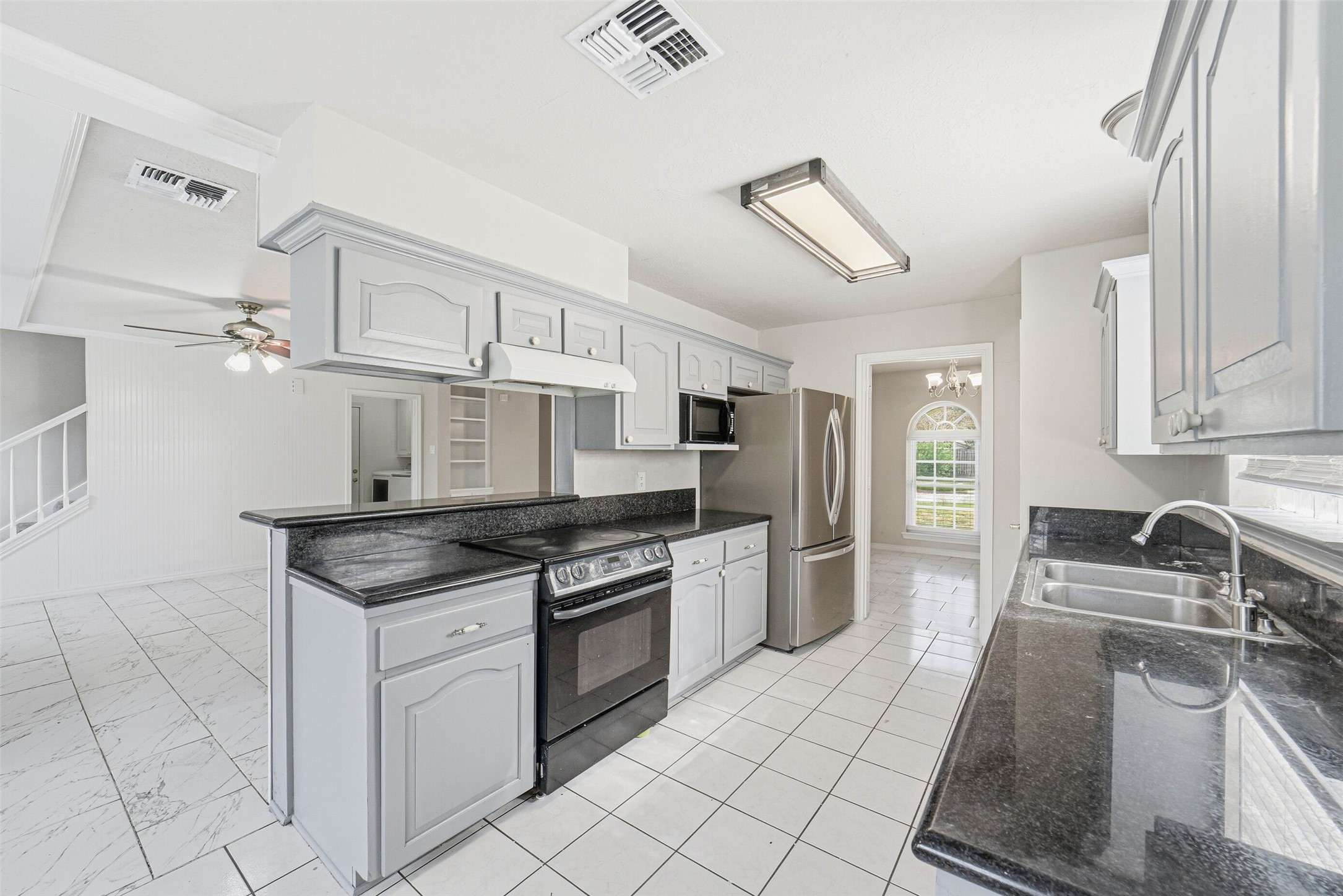 2406 Joel Wheaton Road Houston, TX 77077 - Photo 13 of 36 a kitchen with granite countertop a sink stove and cabinets
