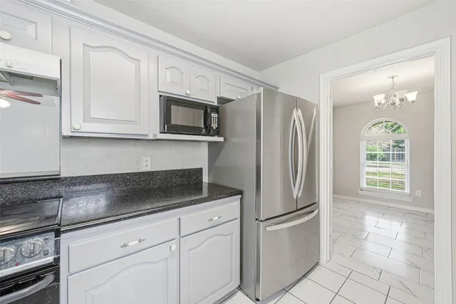 a kitchen with stainless steel appliances granite countertop a refrigerator a microwave and cabinets