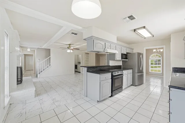 a large kitchen with cabinets and stainless steel appliances