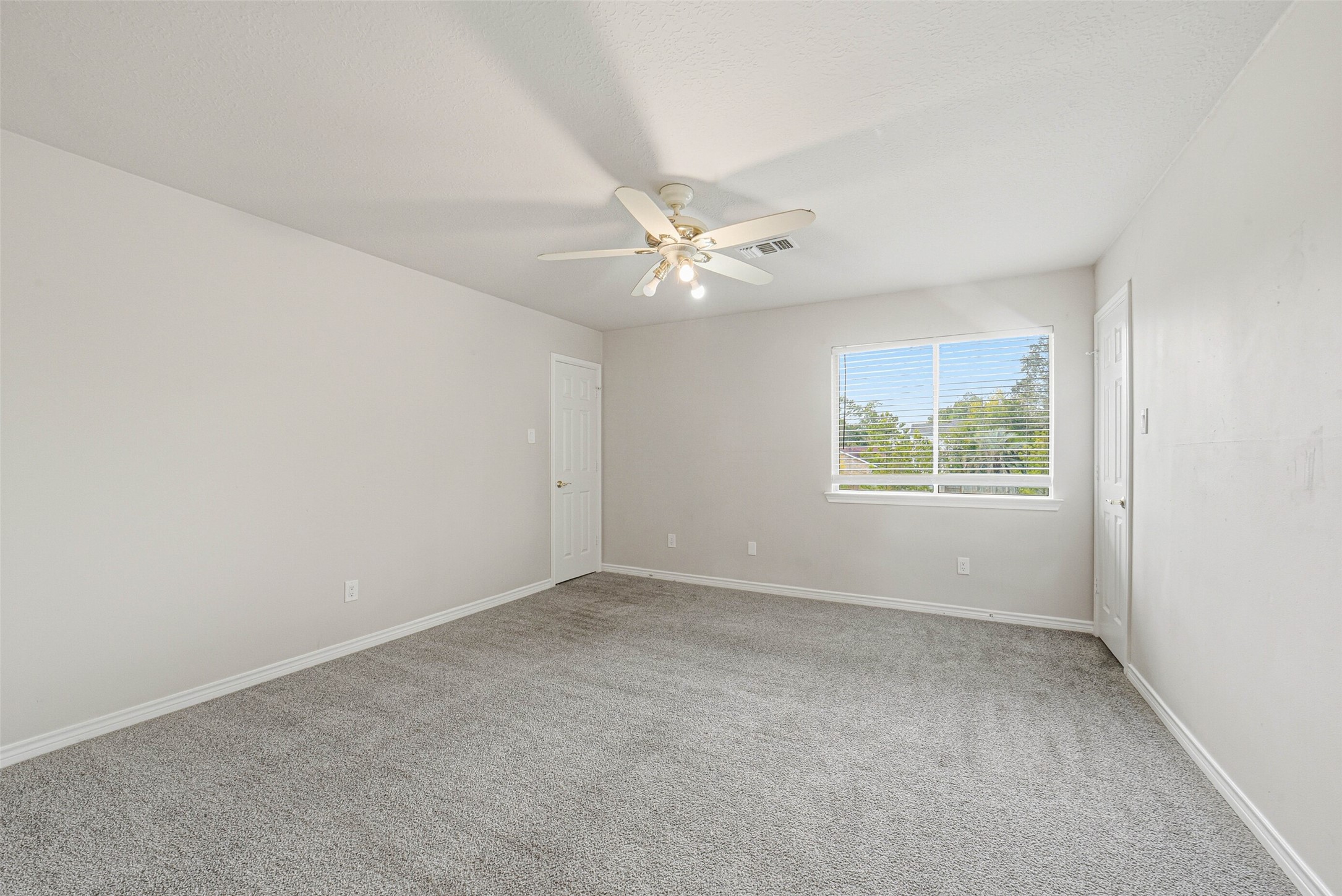 2406 Joel Wheaton Road Houston, TX 77077 - Photo 26 of 36 an empty room with windows and fan