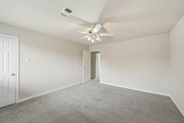an empty room with a ceiling fan and a window