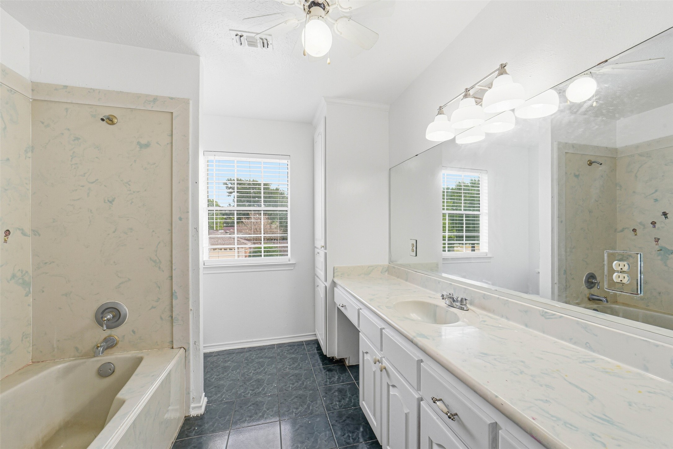 2406 Joel Wheaton Road Houston, TX 77077 - Photo 28 of 36 a bathroom with a granite countertop sink a large mirror and a bathtub