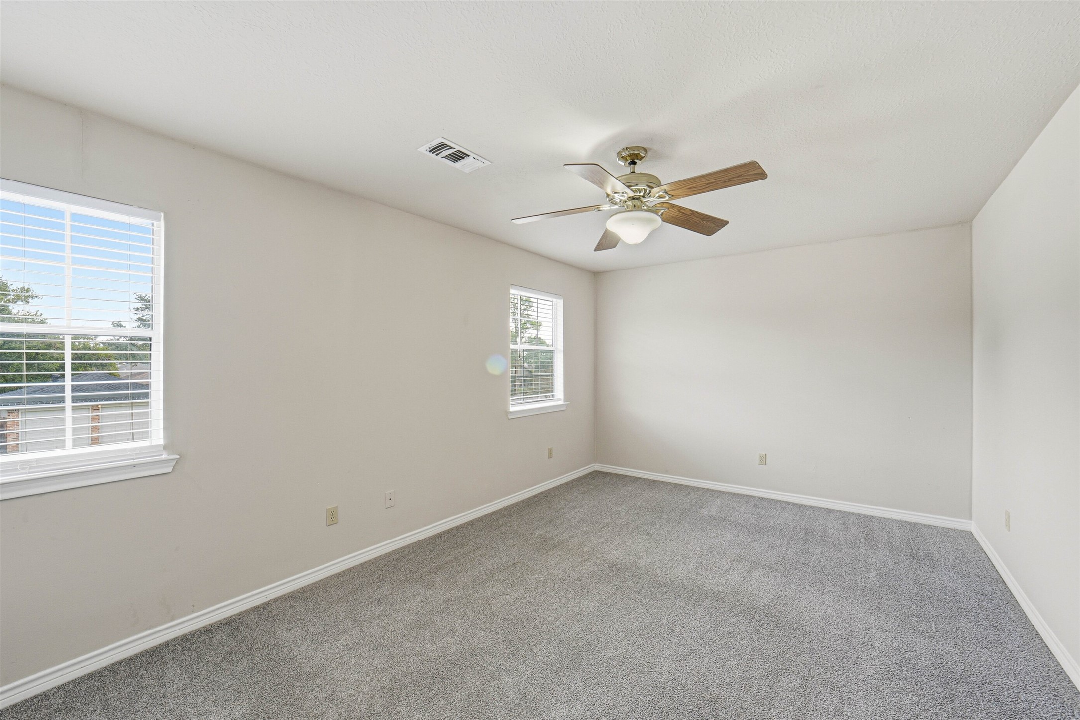 2406 Joel Wheaton Road Houston, TX 77077 - Photo 29 of 36 an empty room with a window and a ceiling fan