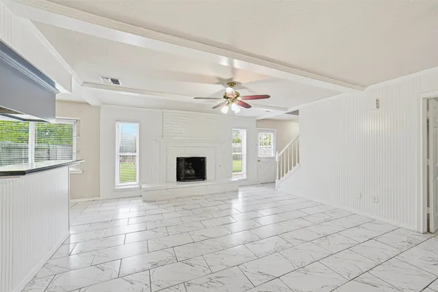 a view of an empty room with a fireplace and a window