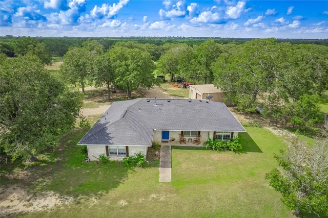 a aerial view of a house with garden space and a patio