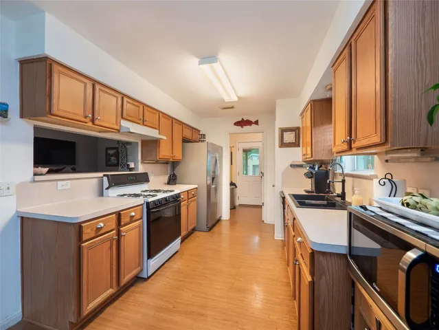 a kitchen with stainless steel appliances a stove sink microwave and cabinets