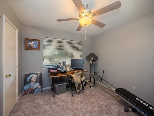 a view of a workspace with furniture and a window
