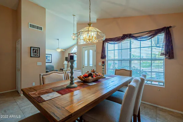 a kitchen with stainless steel appliances kitchen island granite countertop a table chairs and a refrigerator