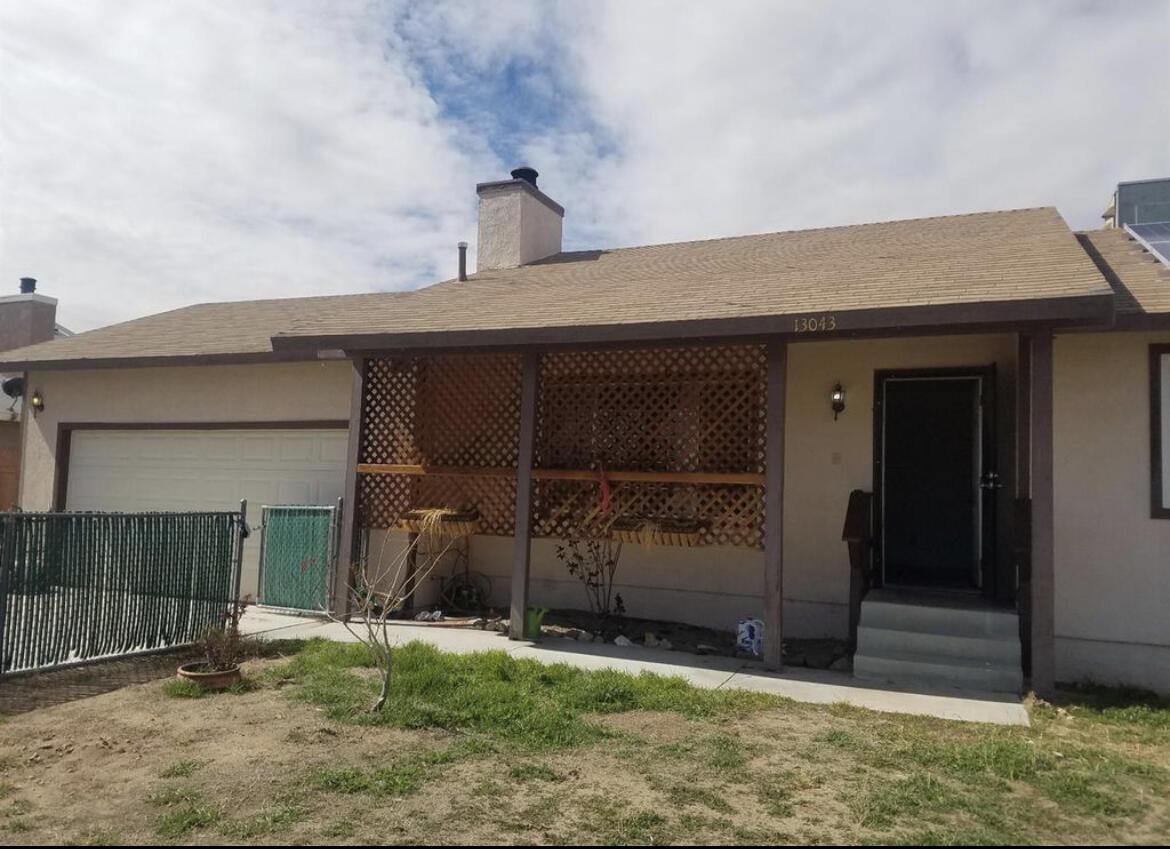 13043 Clement Street North Edwards, CA 93523 - Photo 3 of 4 a front view of a house with a yard and garage