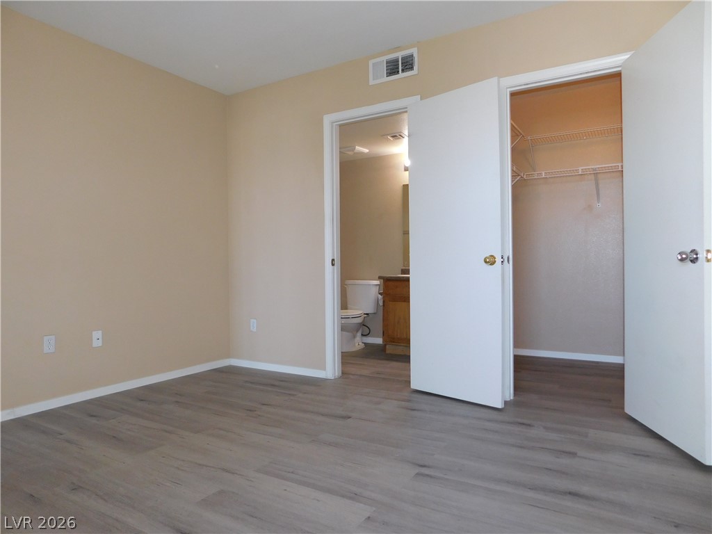 7255 West Sunset Road, Unit 2029 Las Vegas, NV 89113 - Photo 10 of 21 An airy bedroom with resilient wood flooring provides direct access to a well-organized walk-in closet and a private bathroom.