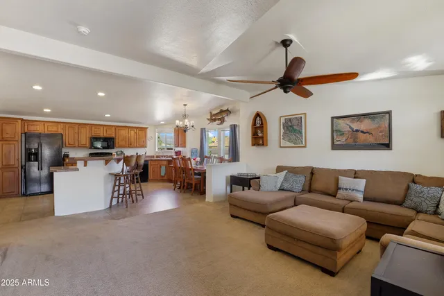 a living room with furniture kitchen view and a chandelier
