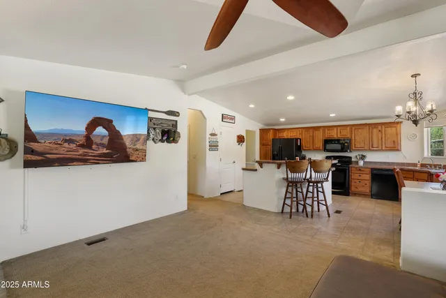 a living room with furniture kitchen view and a wooden floor