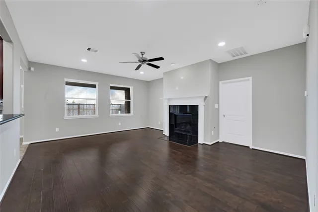 a view of an empty room with a fireplace and a window
