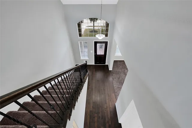 a view of a hallway with wooden floor and staircase
